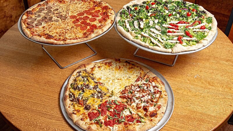 Multiple pizzas on display on a table